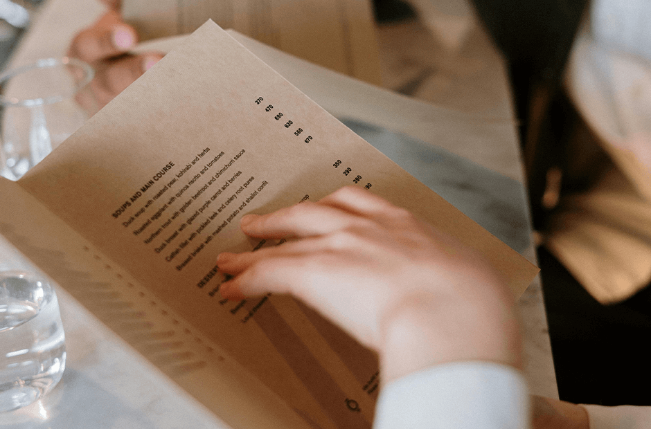 Person Holding White Printer Paper Menu