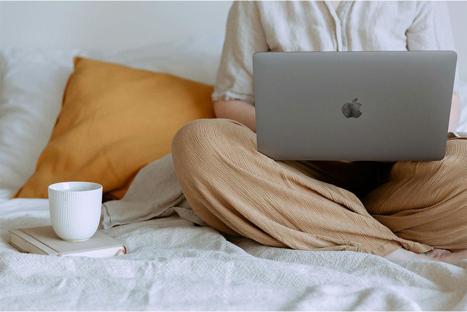Woman using laptop in bedroom