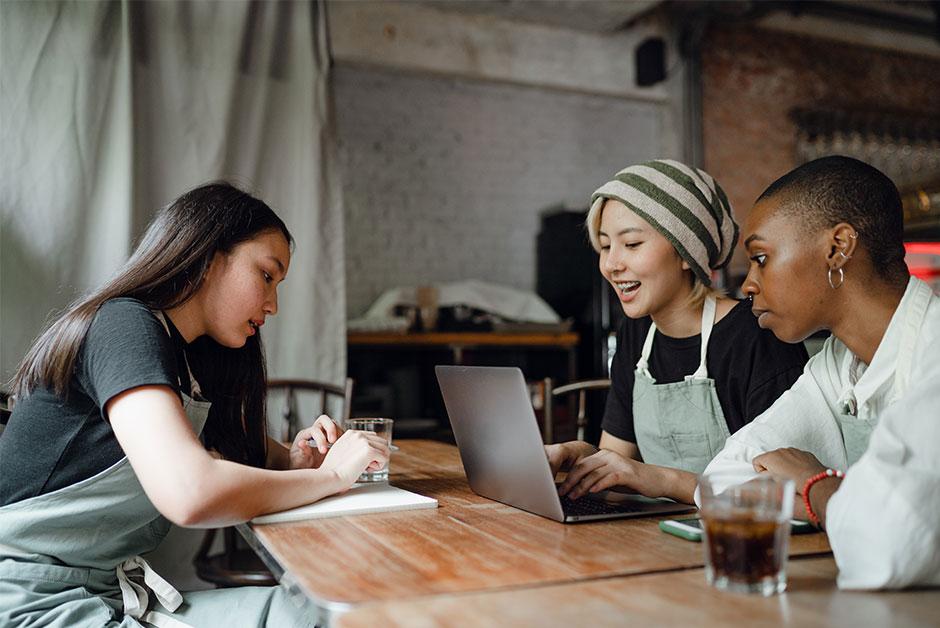 Group of young women around computer 