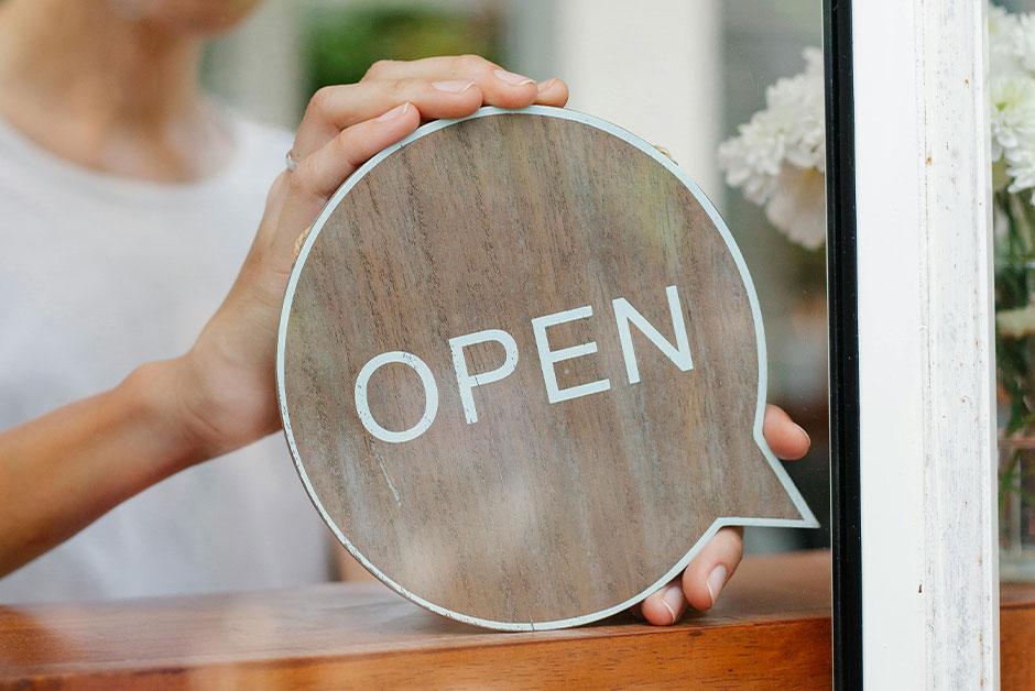 cheerful woman with Open sign - Pexels - Douglas